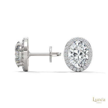 1.25 CT oval lab-grown diamond stud earrings in 14K white gold with a pavé halo setting.