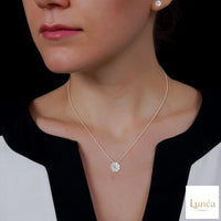 Floral cluster lab-grown diamond earrings and matching pendant necklace in white gold on a model.