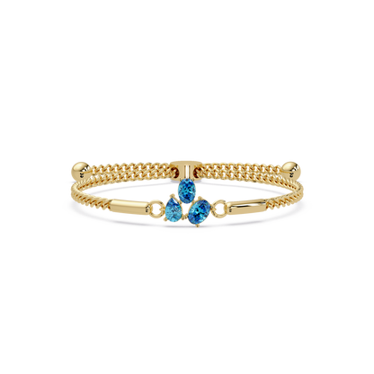 Three-stone pear and oval colorstone hinged bangle in yellow gold with aquamarine stones