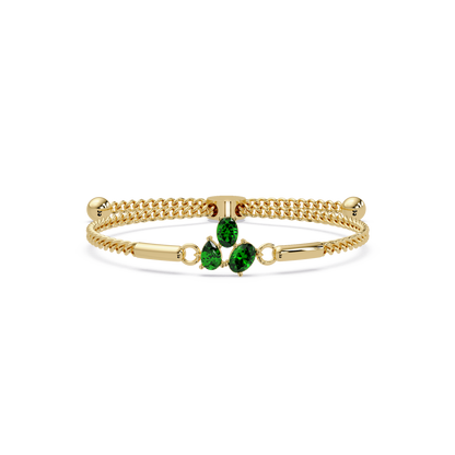 Three-stone pear and oval colorstone hinged bangle in yellow gold with green stones