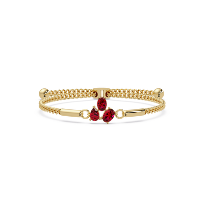 Three-stone pear and oval colorstone hinged bangle in yellow gold with red stones