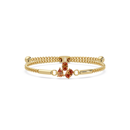 Three-stone pear and oval colorstone hinged bangle in yellow gold with topaz stones